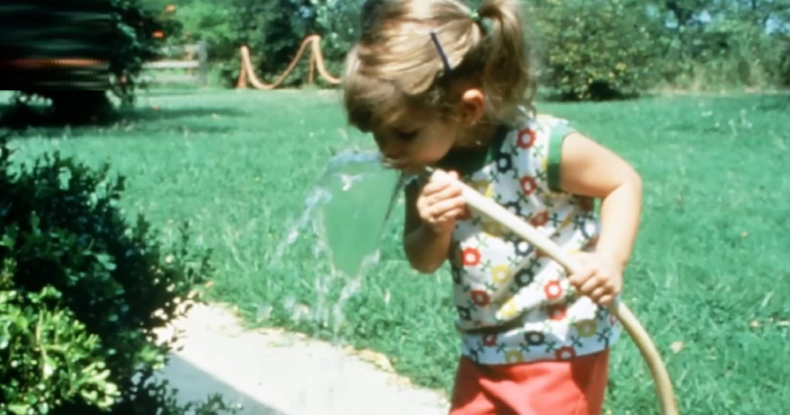 drinking from a garden hose on a hot summer day